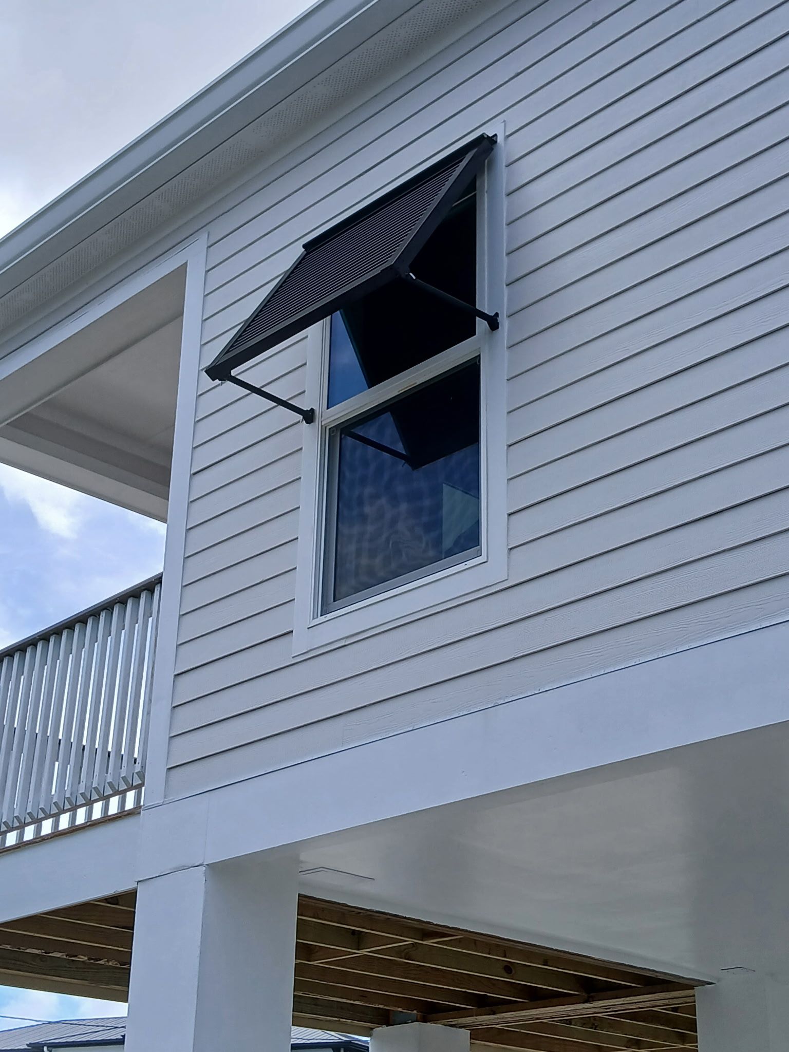 White house with black window awning.