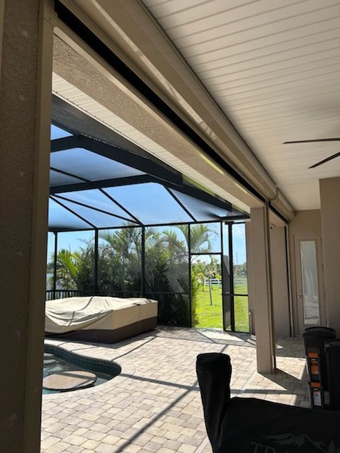 Outdoor patio with pool, screened enclosure, and retractable shades.