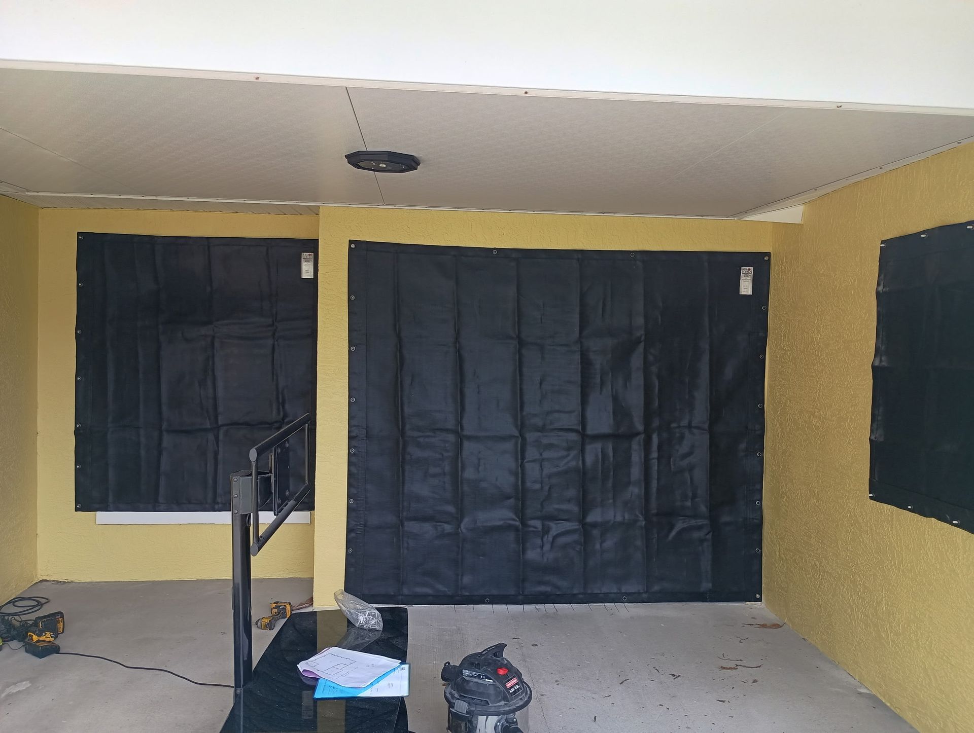 Yellow exterior wall with black window coverings.