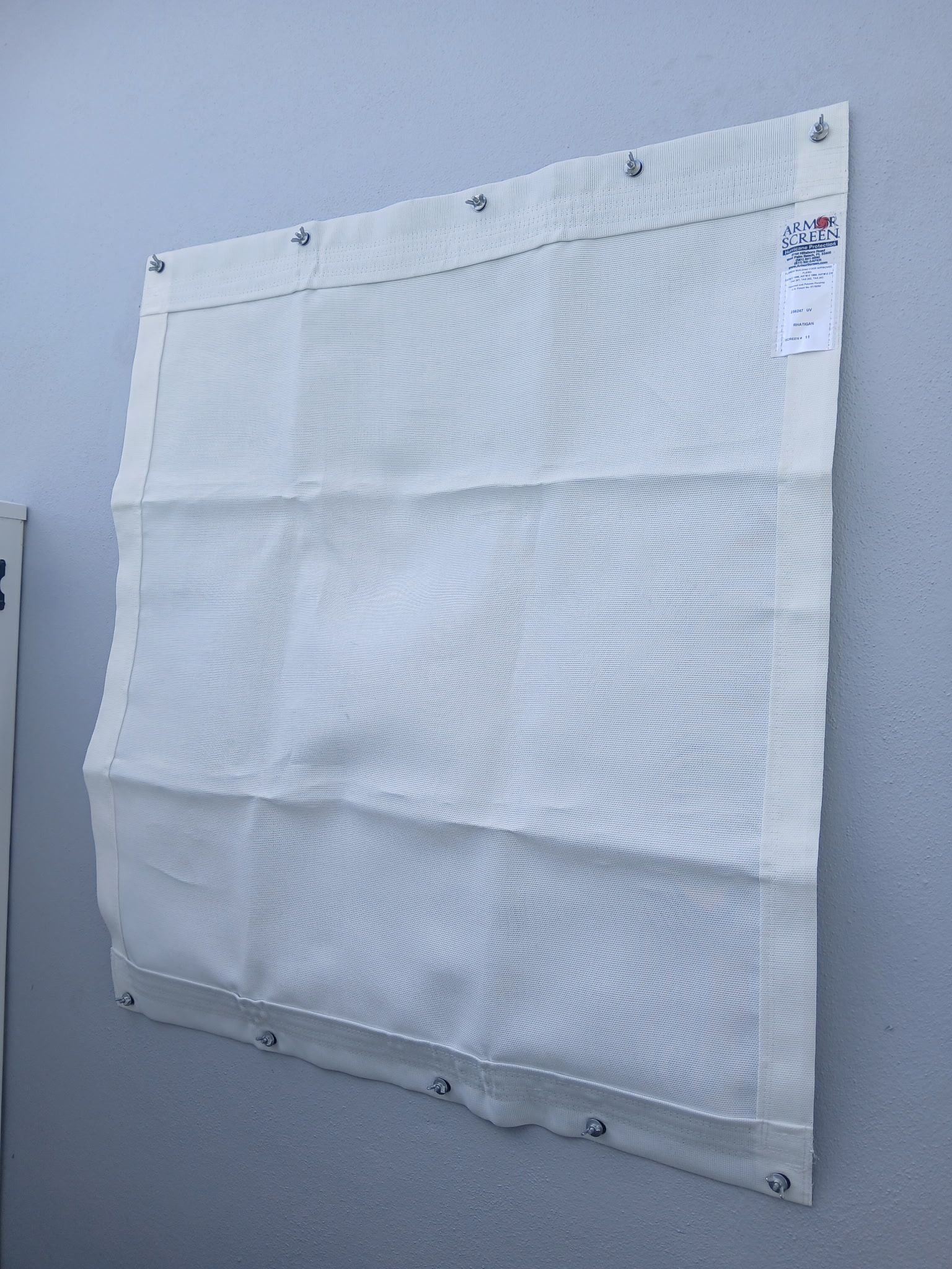 White mesh safety net attached to a gray wall.