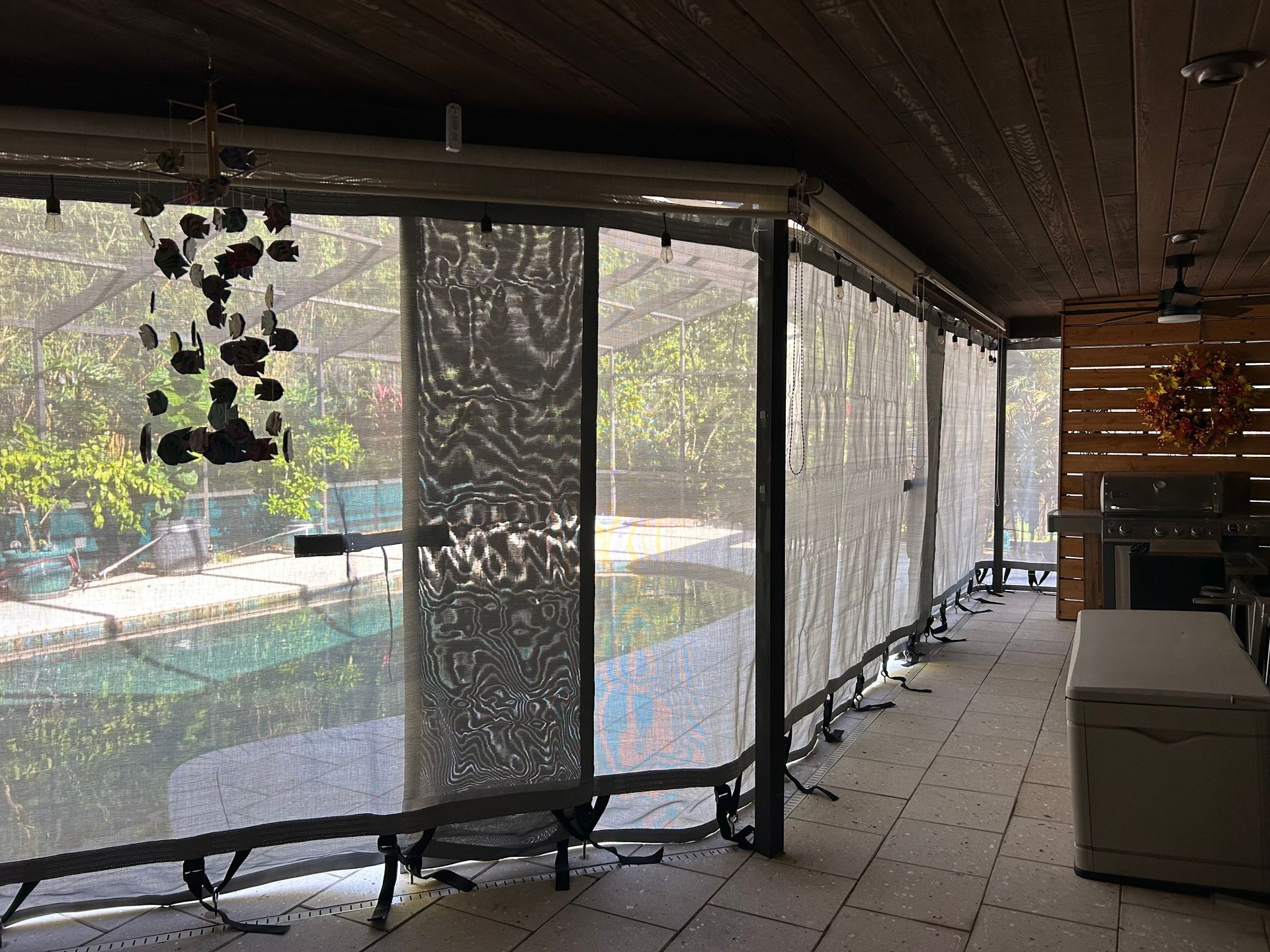Patio with retractable screens overlooking a pool area.