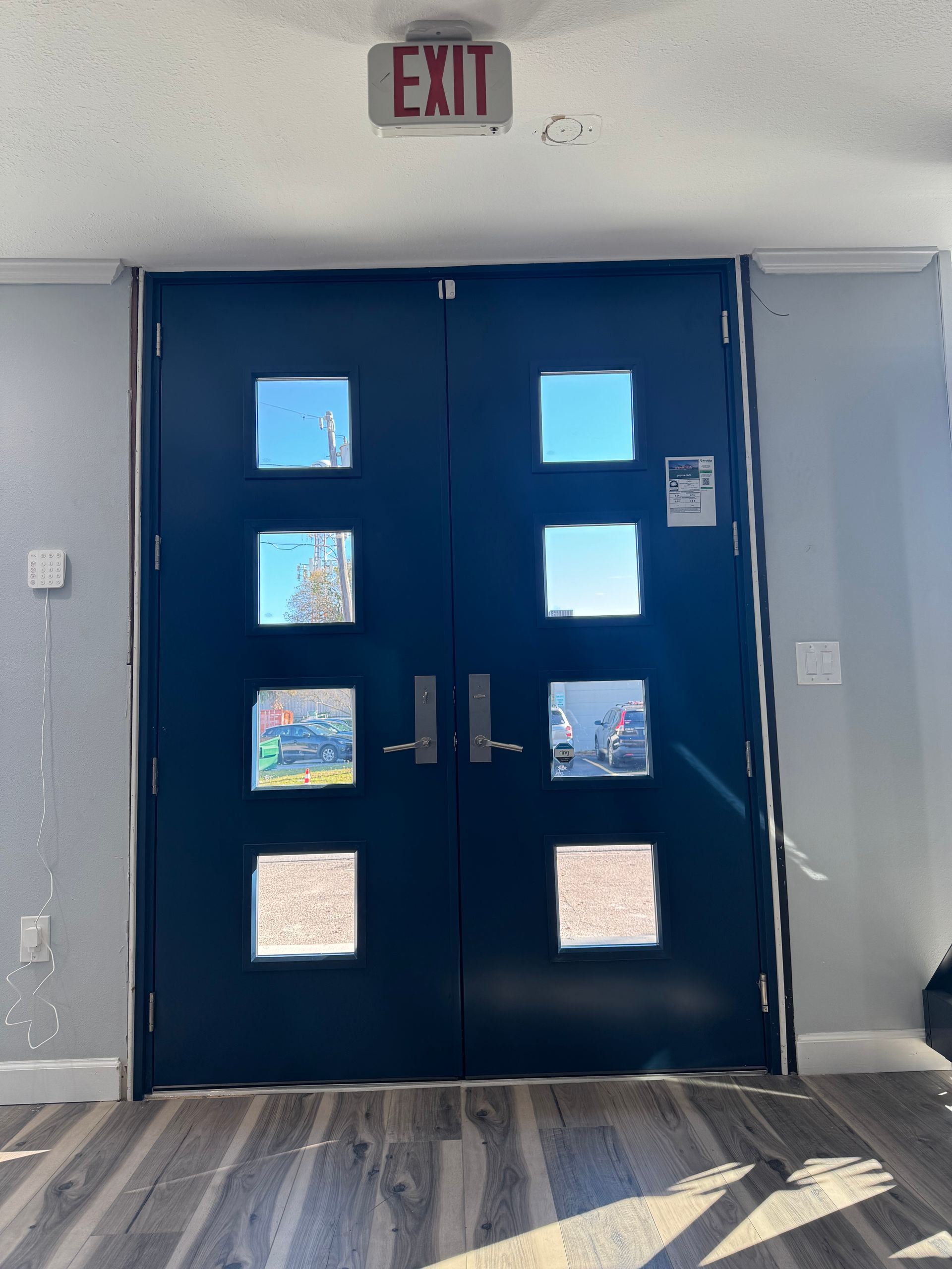 Dark blue double doors with square windows. An