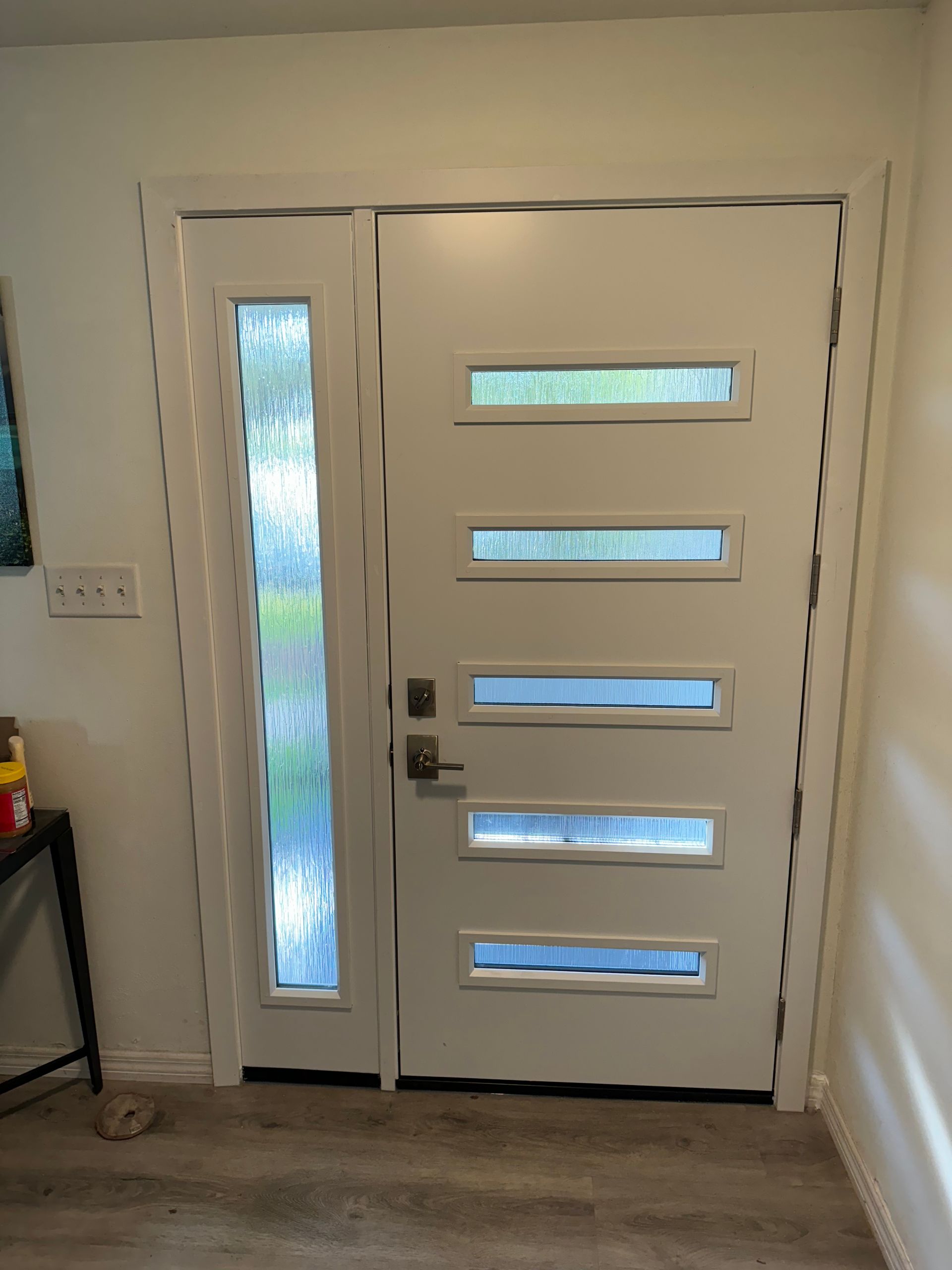White modern door with sidelight and multiple horizontal window panes.