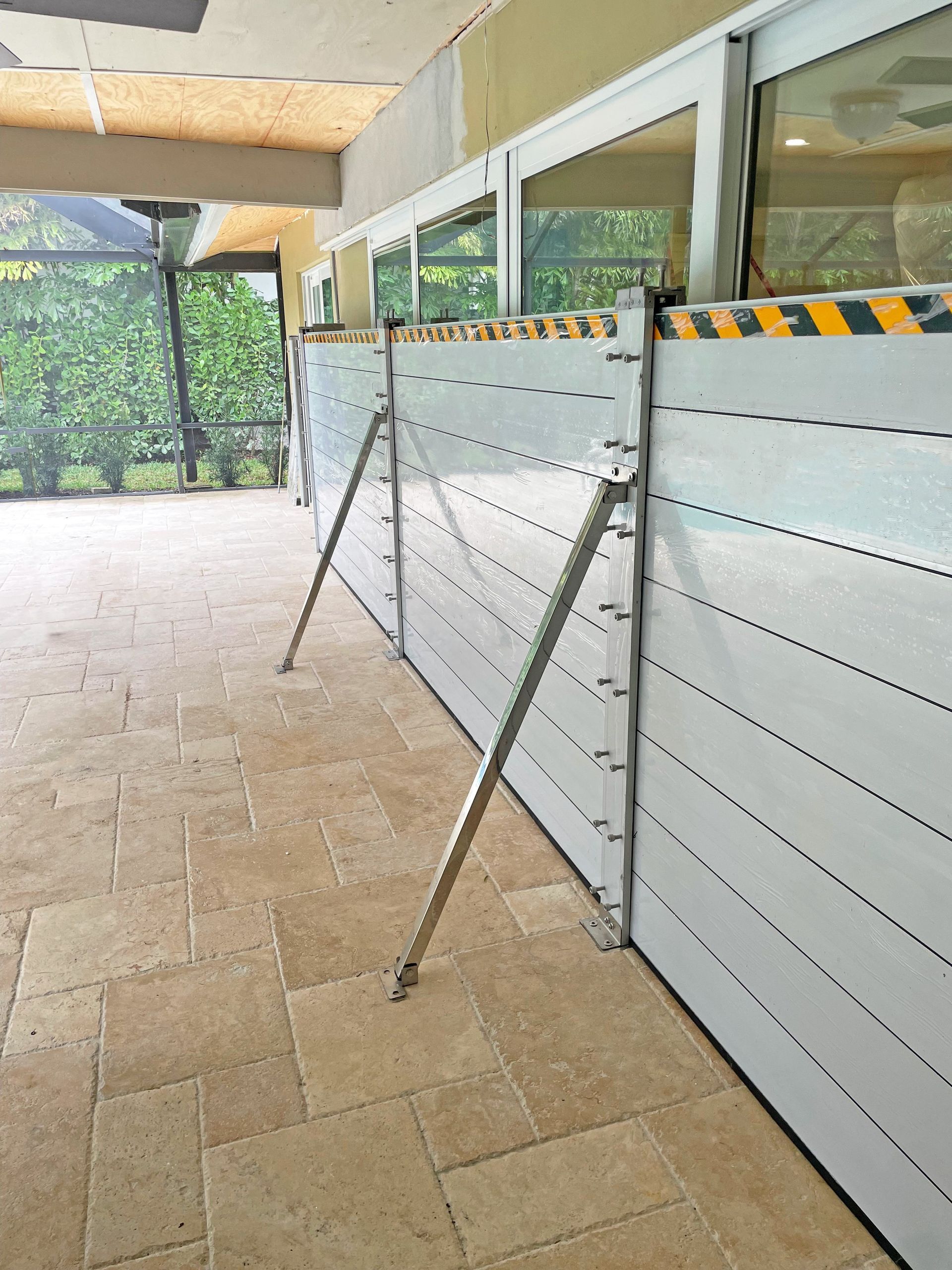 Flood barrier erected along a building's facade, secured with angled metal supports.