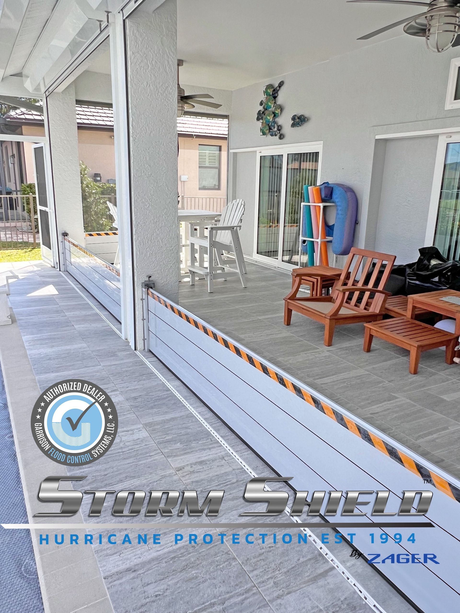 Patio with retractable hurricane shutters, pool in foreground. Grey, white, orange accents.