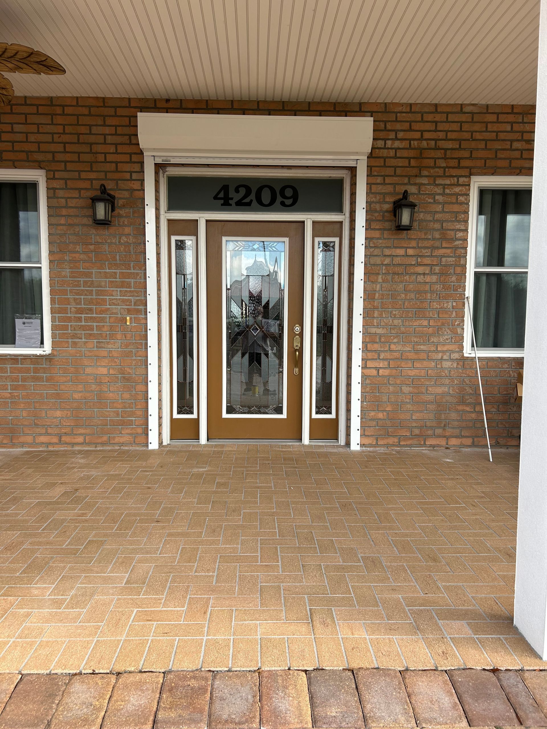 Front door of a brick house with sidelights and address 4209 above the door.
