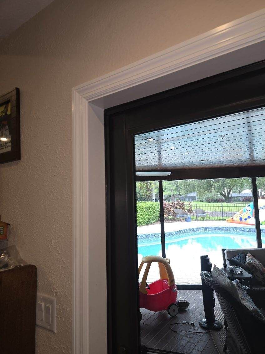 Sliding glass door frame. A pool and yard are visible through the door. A toy car sits nearby.