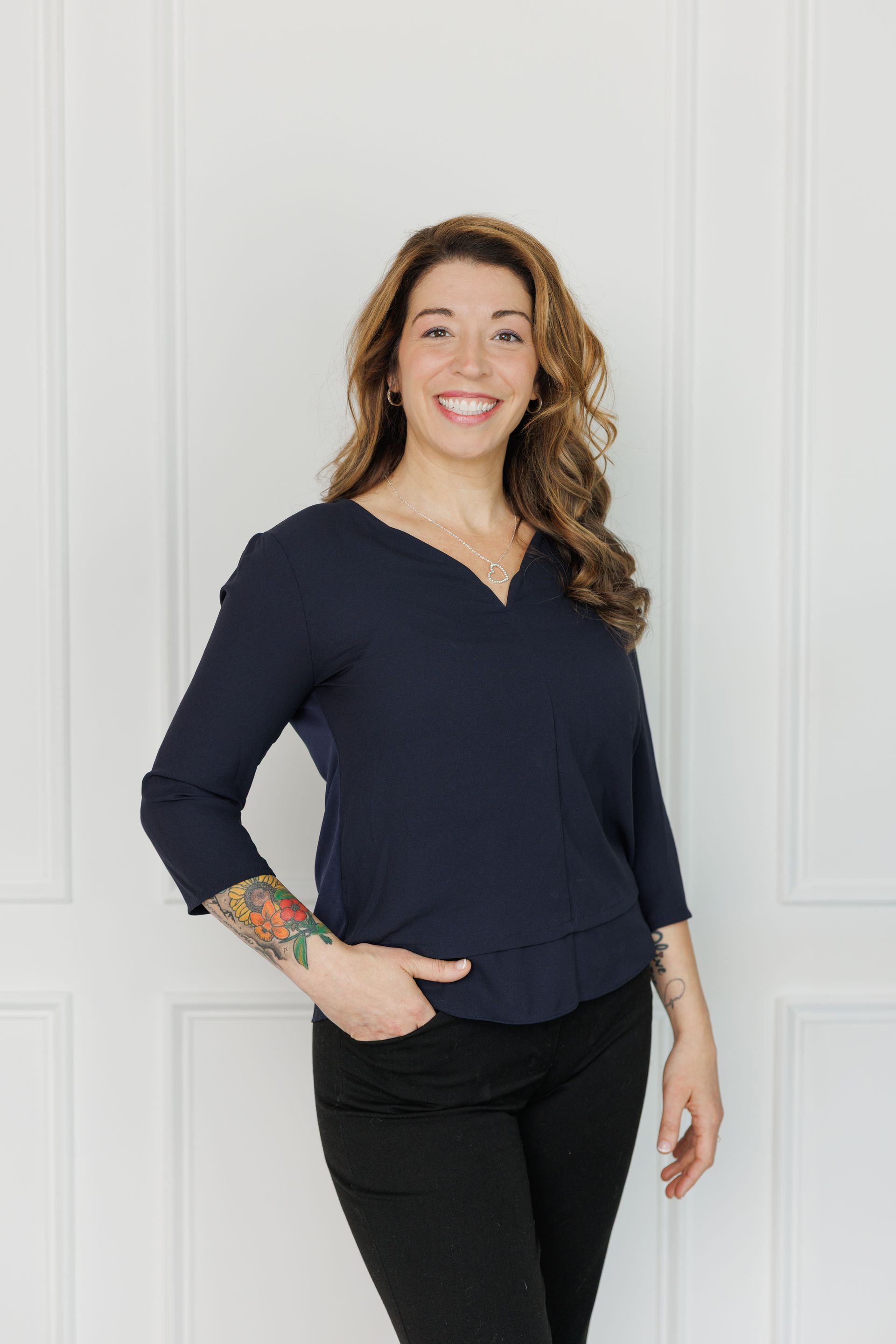 A close up of a woman 's face smiling and wearing earrings.