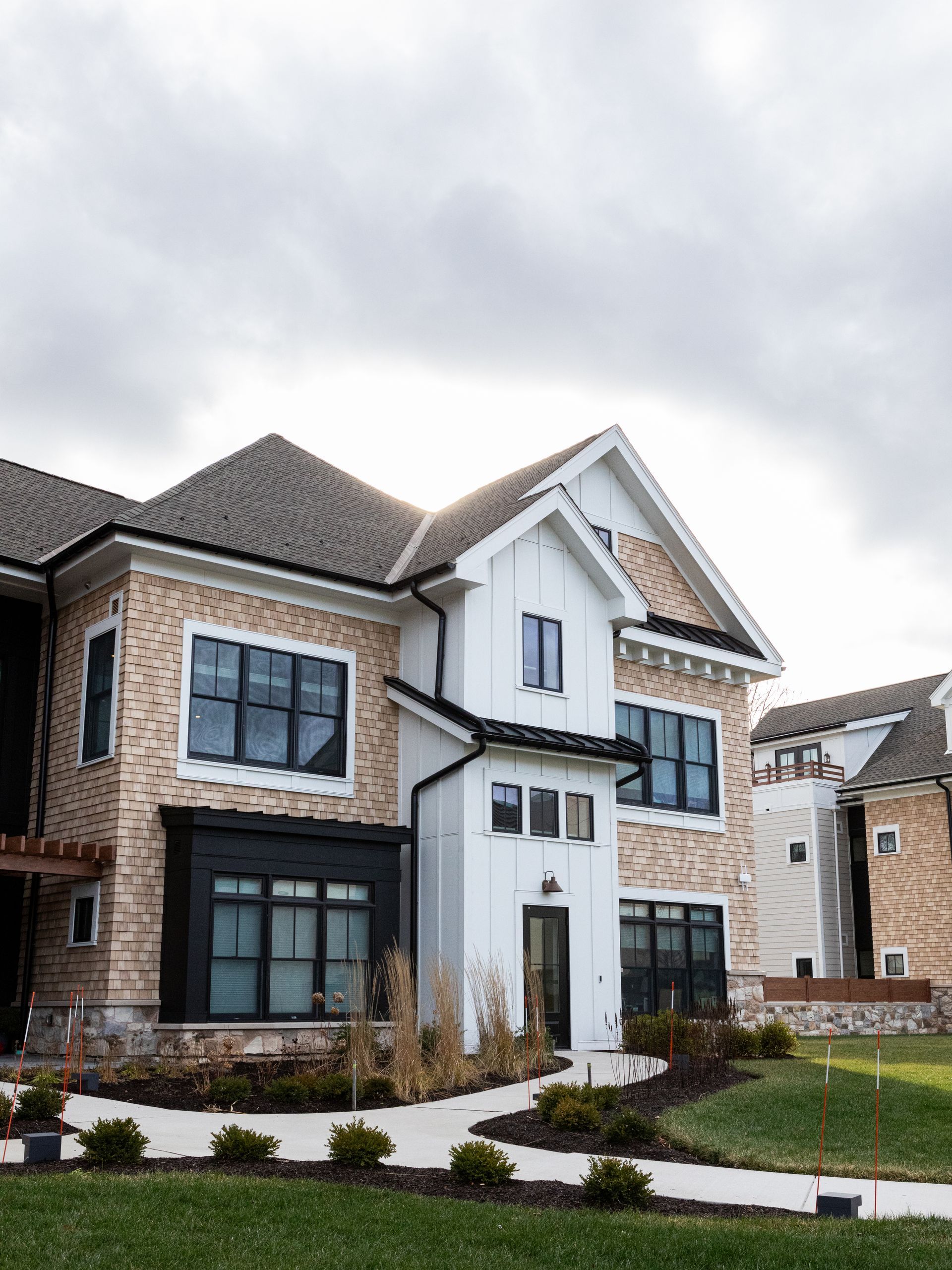 A large house with a lot of windows is sitting on top of a lush green lawn.