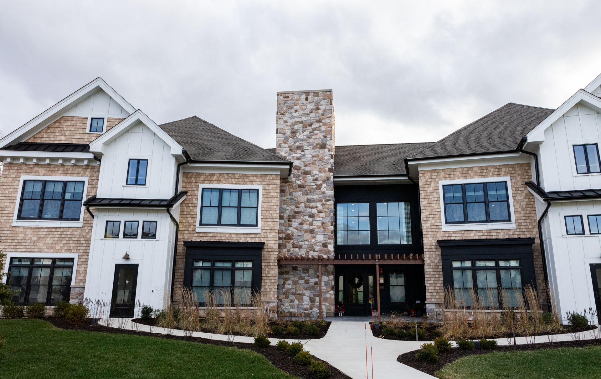 A large house with a lot of windows and a stone chimney.