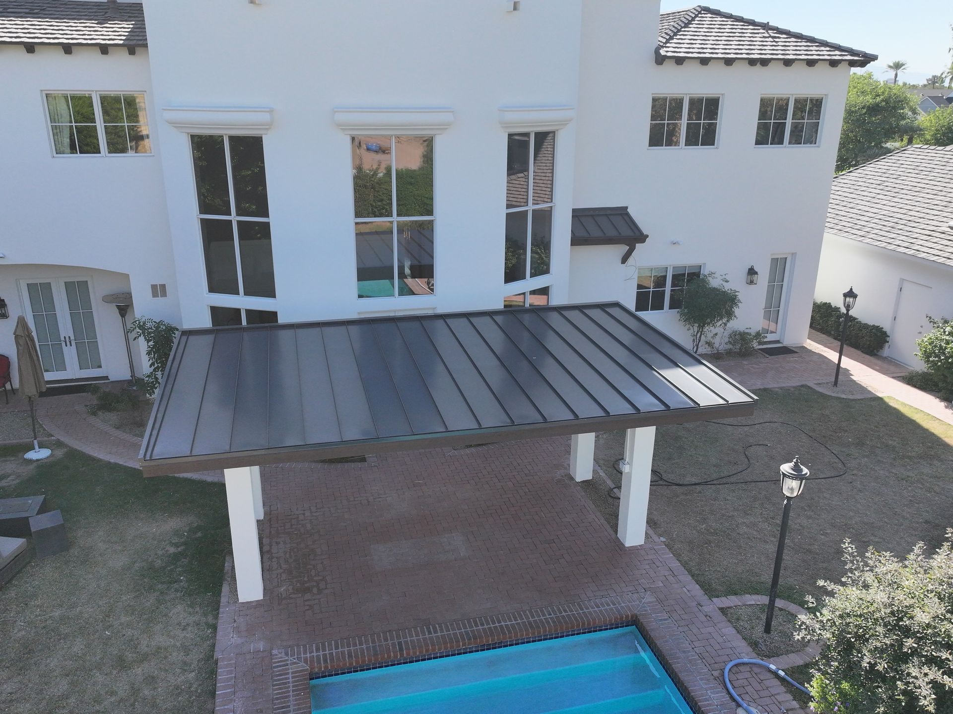 an aerial view of a house with a pool in front of it