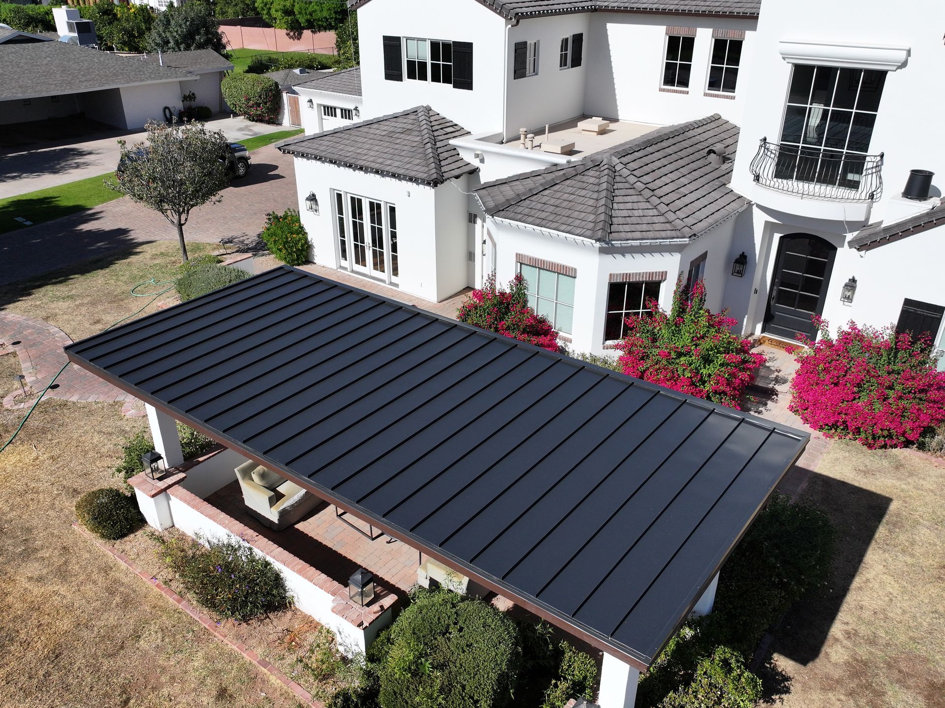 an aerial view of a large white house with a black roof