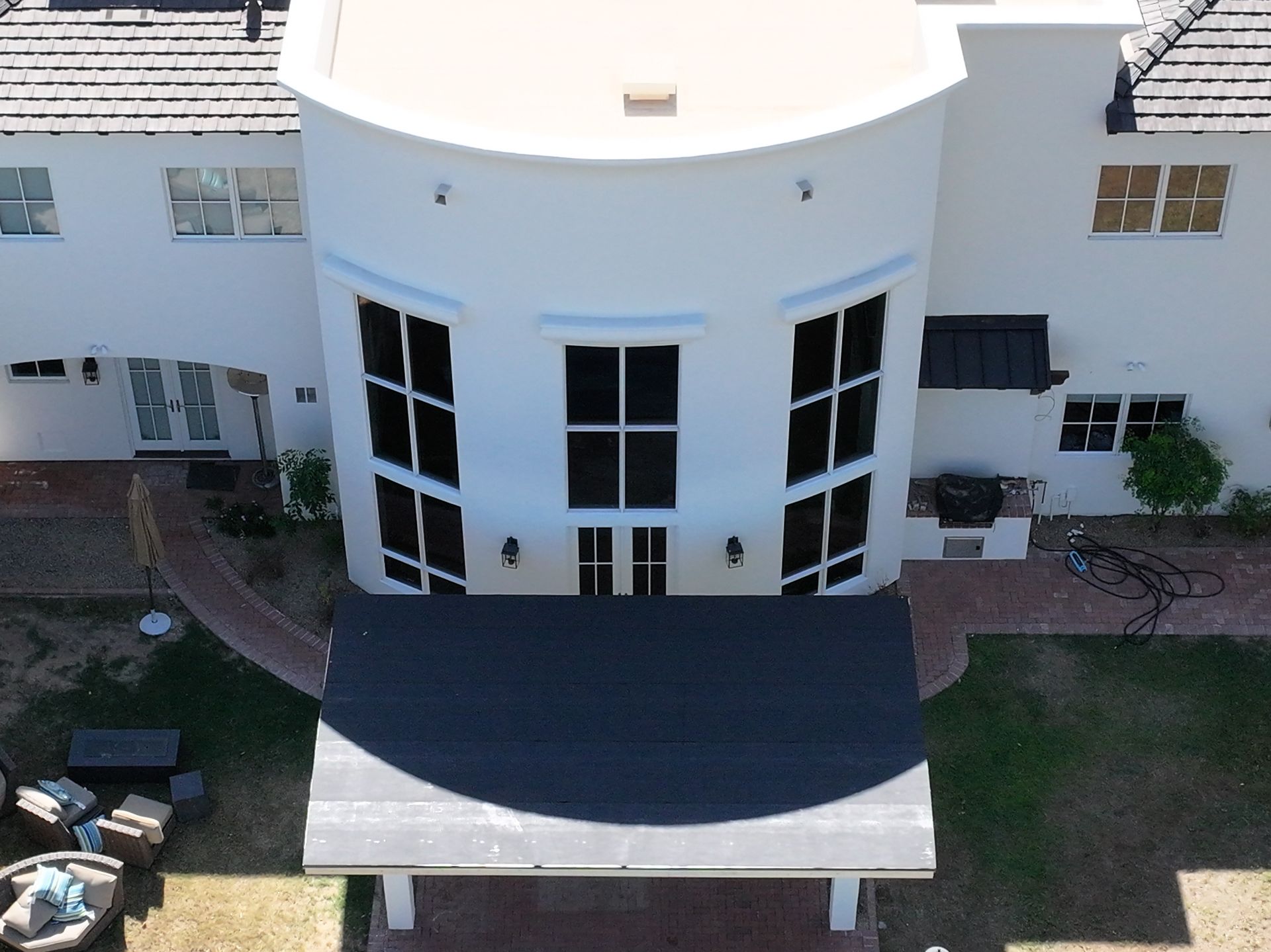 an aerial view of a white house with black windows