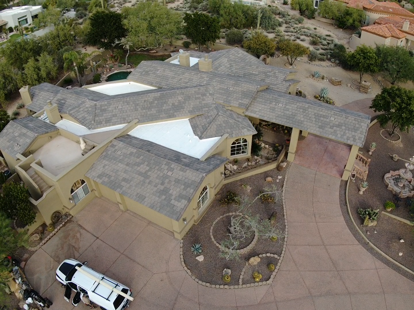an aerial view of a large house with a limousine parked in front of it