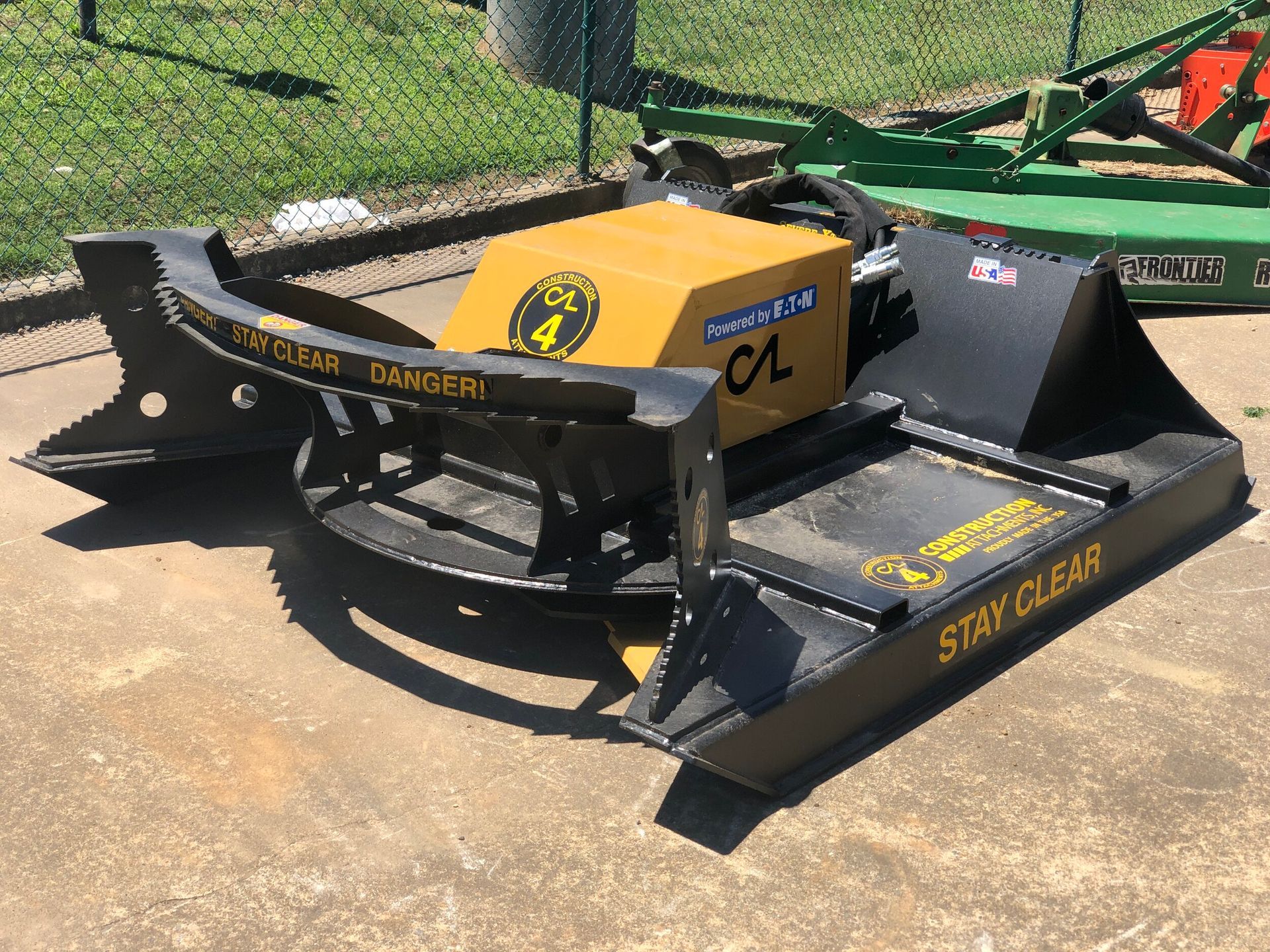 Yellow and black industrial brush cutter on concrete, with 