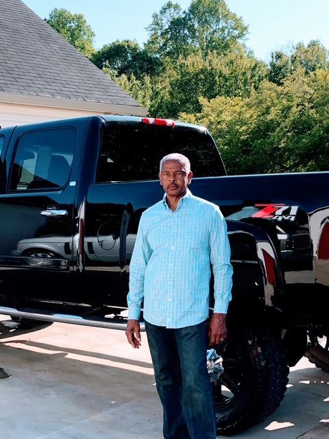 A man is standing next to a white van in a parking lot