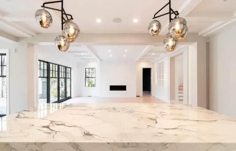 Bright, empty modern living room with marble floors, black-framed windows, and pendant lights
