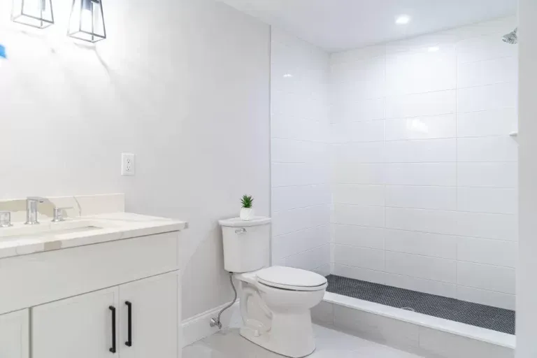Bright white modern bathroom with vanity, toilet, and tiled walk-in shower