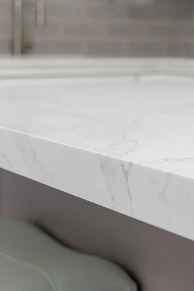 White marble countertop with gray veining above a built-in bench or seat in a modern interior