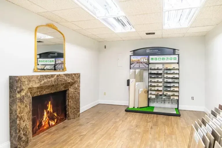 Empty room with wood floor, stone fireplace, and display rack against white walls
