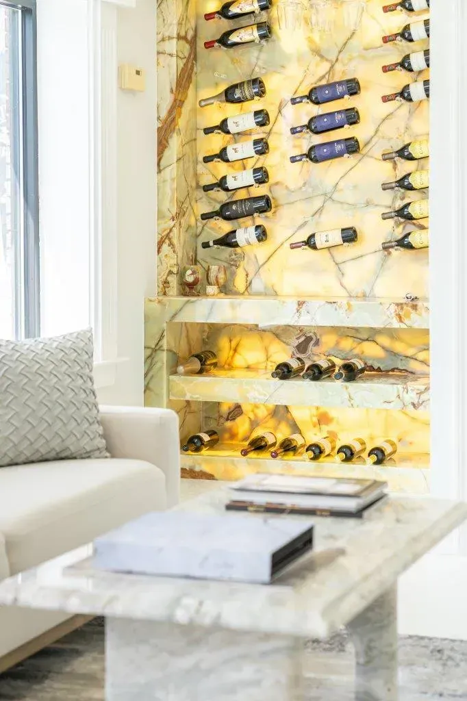 Bright living room with a marble coffee table and a wall-mounted wine rack installation.