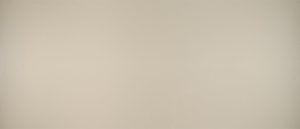 Blank beige wall with soft lighting and a faint shadow near the bottom