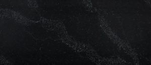 Dark, textured close-up of a black surface with faint gray specks