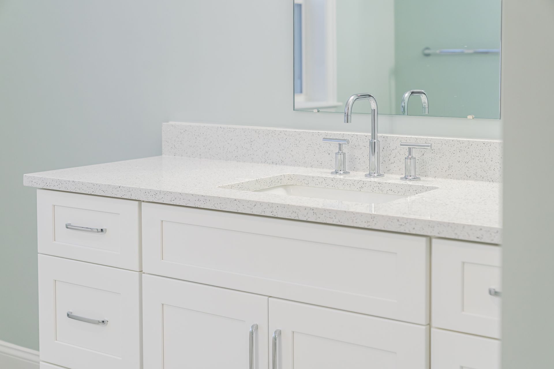 Bright white bathroom vanity with double sink, chrome faucets, and a large mirror