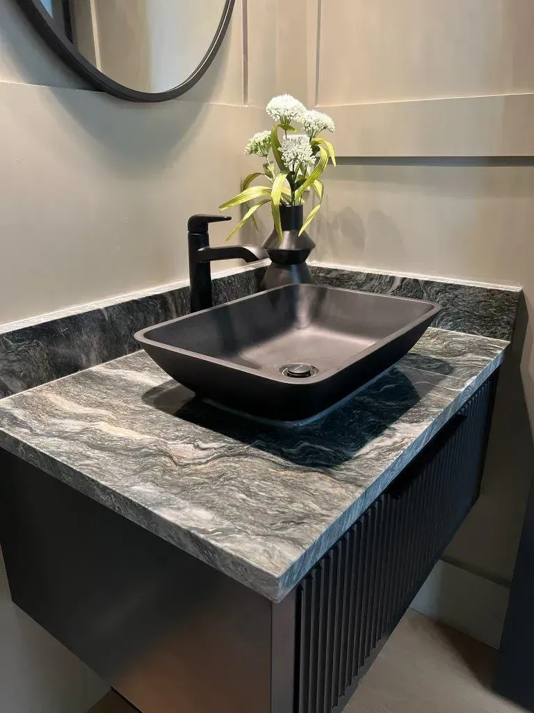 Modern bathroom vanity with black square sink, matte black faucet, and small white flowers on the counter