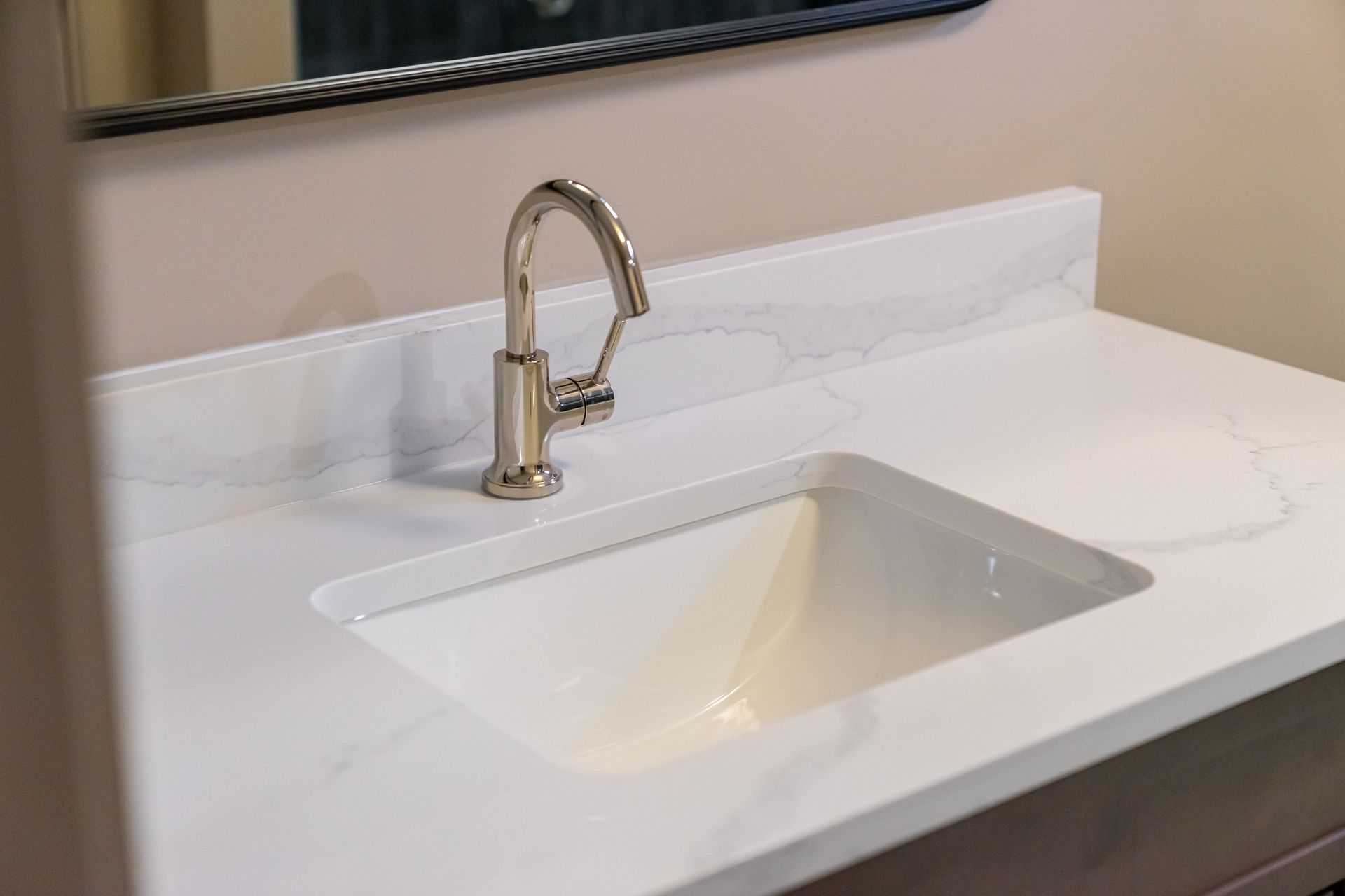 White bathroom vanity with a rectangular sink and chrome faucet