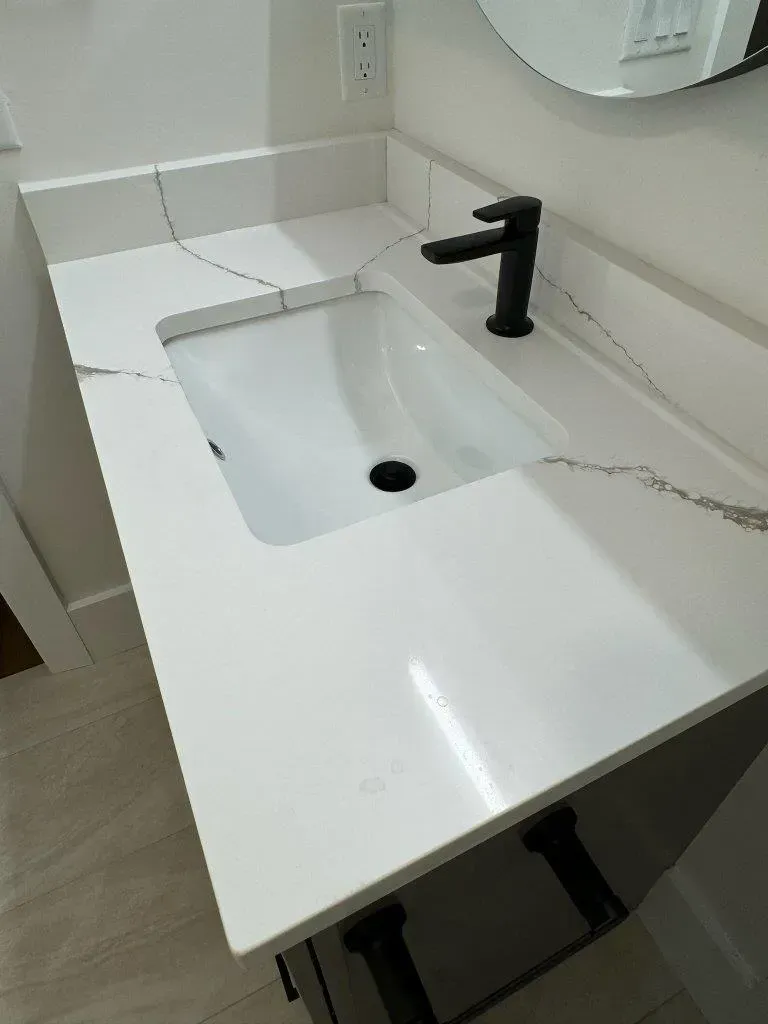 Modern white bathroom vanity with rectangular sink and black faucet, close-up view