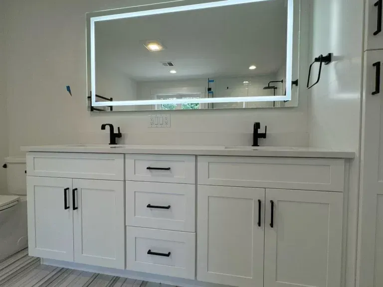 Modern white bathroom vanity with double sinks and a large mirrored cabinet