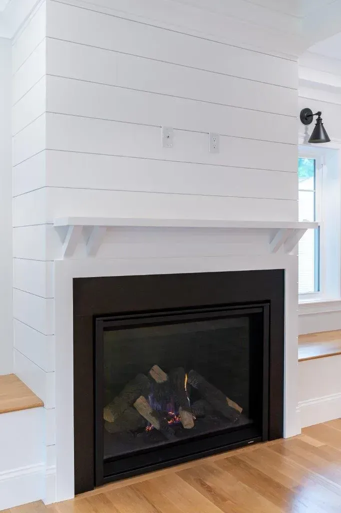 Modern white living room fireplace with black insert and light wood floor