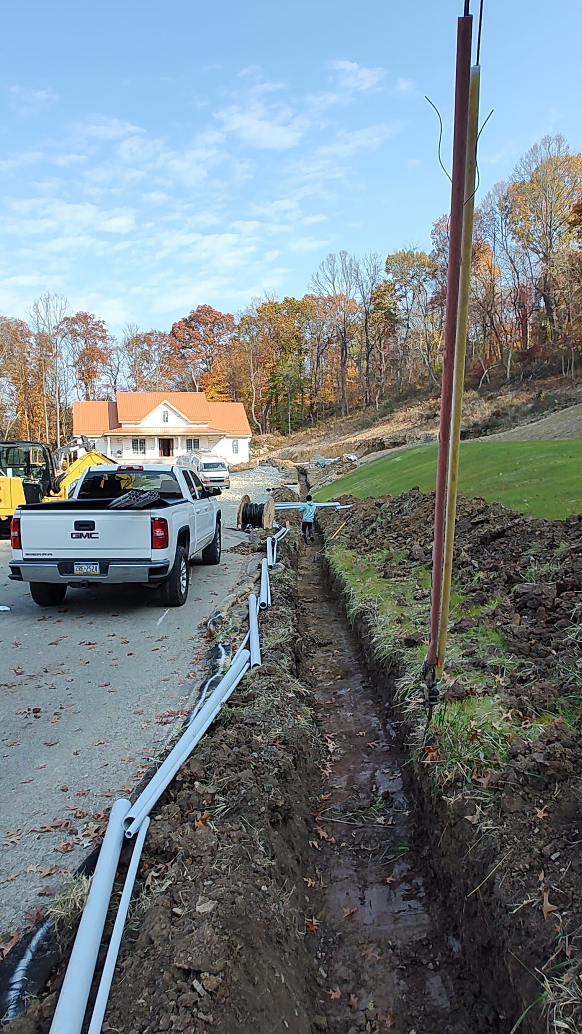 A white truck is parked on the side of the road next to a muddy field