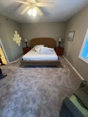 Bedroom with a bed, nightstands, and beige carpet.