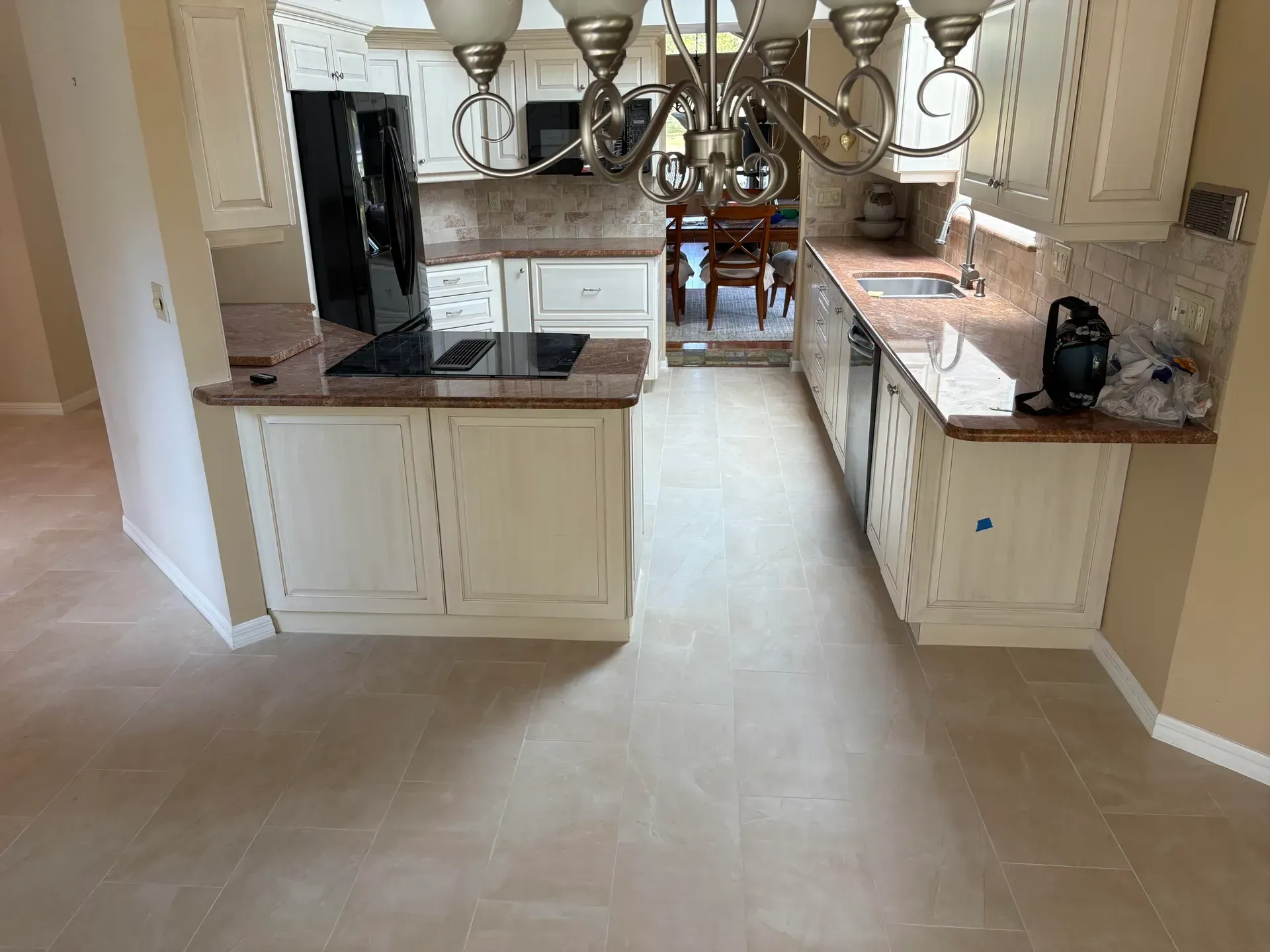 Kitchen with cream cabinets, granite countertops, and tile flooring.
