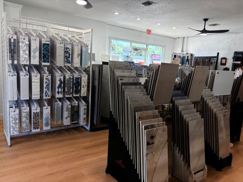 Store interior with rows of flooring samples displayed on racks and stands