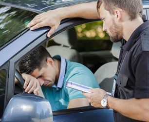 Sad young man in car fined by police officer