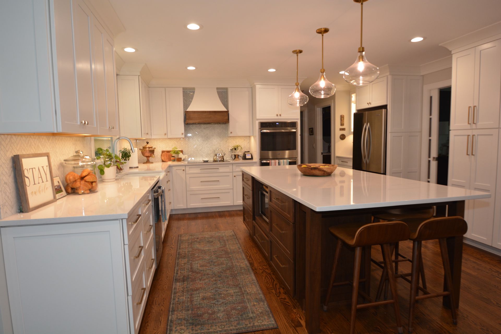 A kitchen with white cabinets and a large island in the middle.