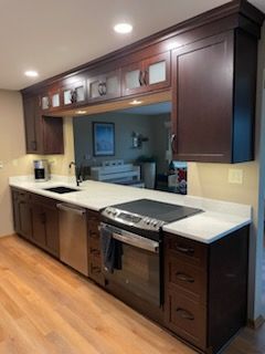 A kitchen with stainless steel appliances and wooden cabinets.