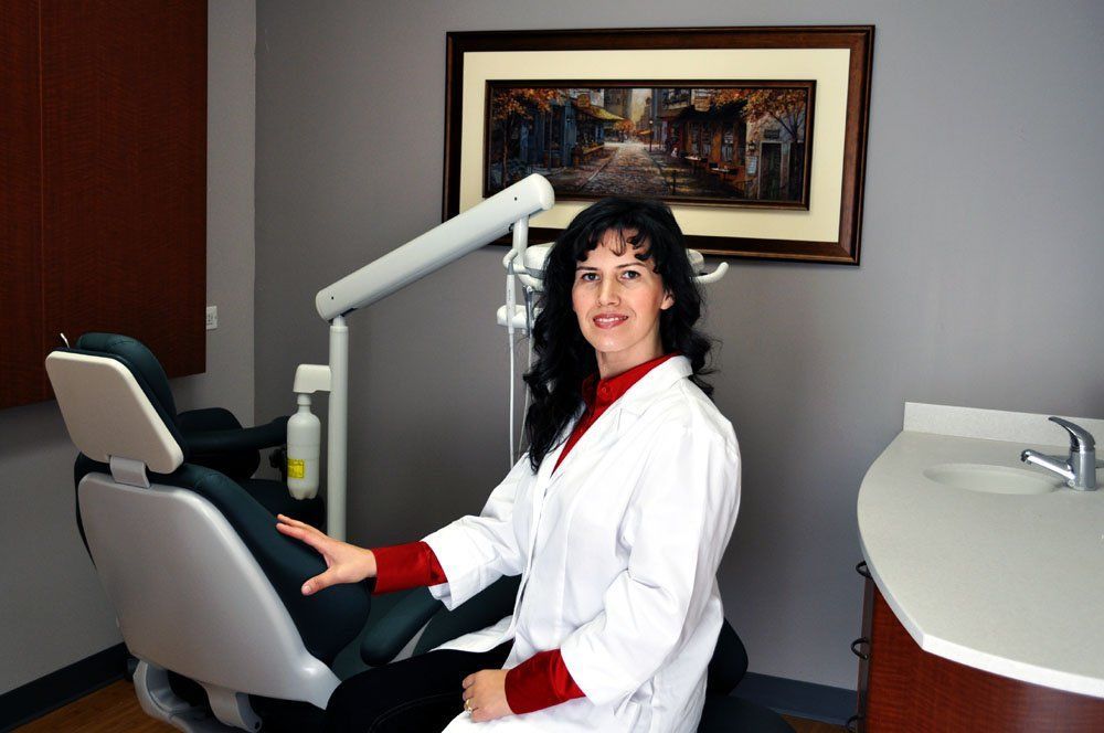 Adina Demian is sitting in a dental chair