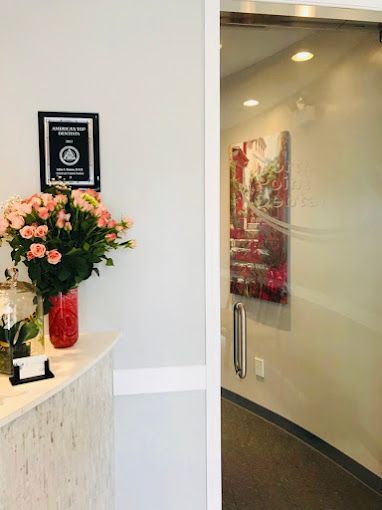 A vase of flowers is sitting on a counter next to a glass door.