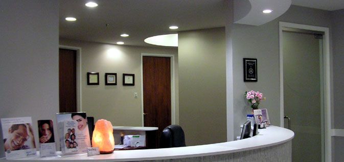 A reception desk in a dental office with a lamp on it