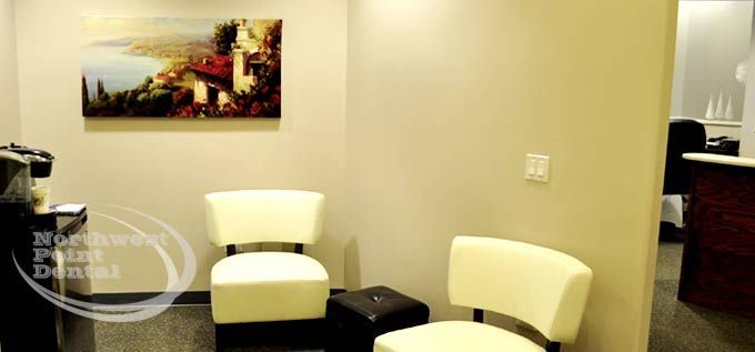 A waiting room with two chairs and a painting on the wall.