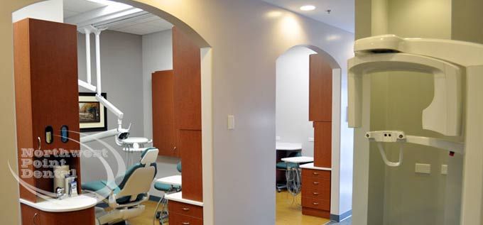 A dental office with a x-ray machine and a dental chair