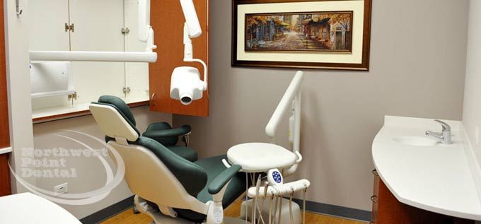 A dental office with a dental chair and a sink.