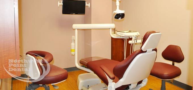A dental office with a dental chair and a monitor