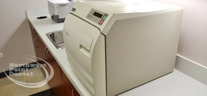 A dental machine is sitting on a counter next to a sink