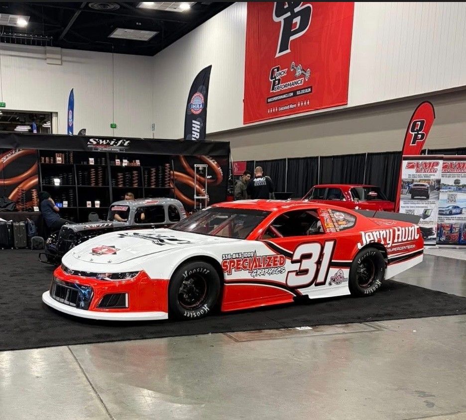 Red and white #31 race car on display at an event.