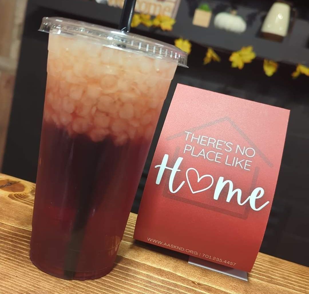 Tall drink with layered red and white liquids, next to a 